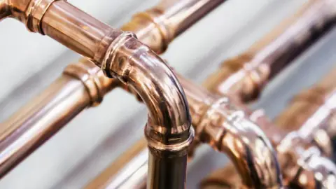 Close view of copper elbow fittings on a pipe run