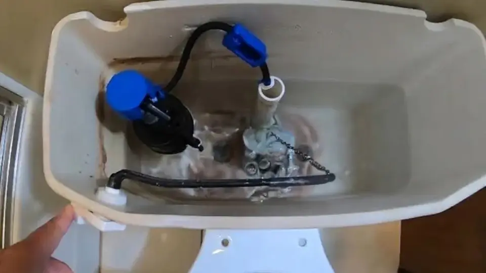 Open toilet tank showing the fill valve and flapper